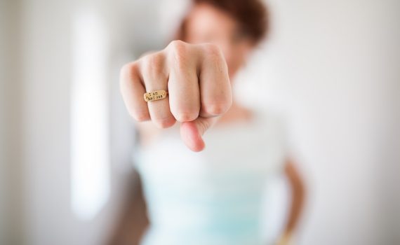woman showing gold-colored ring